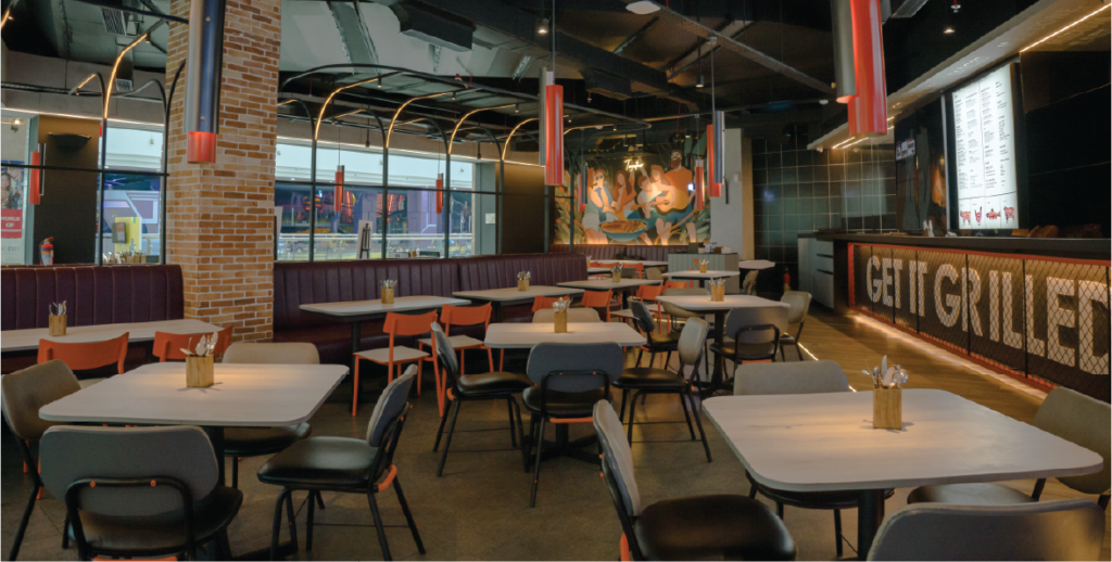 A cozy restaurant interior featuring neatly arranged tables and chairs in the center, inviting guests to dine comfortably.